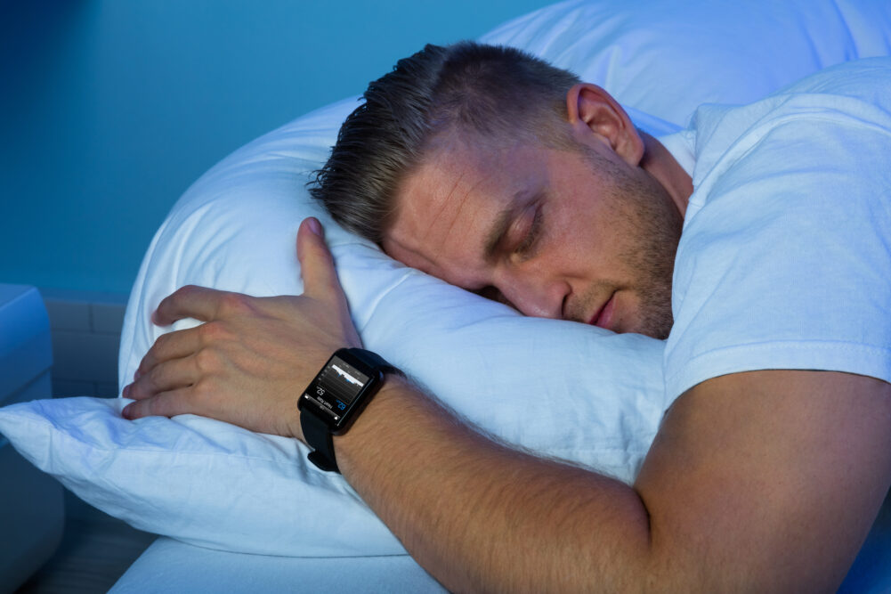 A person with a smartwatch on their wrist, sleeping soundly.