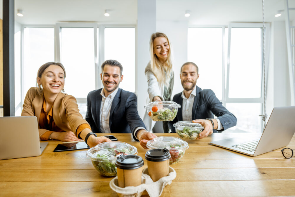 A group of coworkers grabbing some salads and teas during a healthy working lunch.